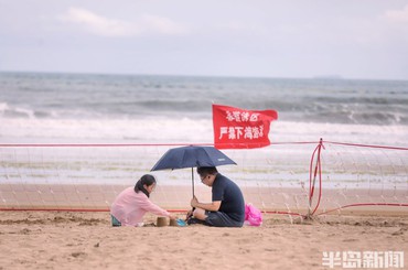 石老人浴场关闭，游客护栏外有序观浪休闲